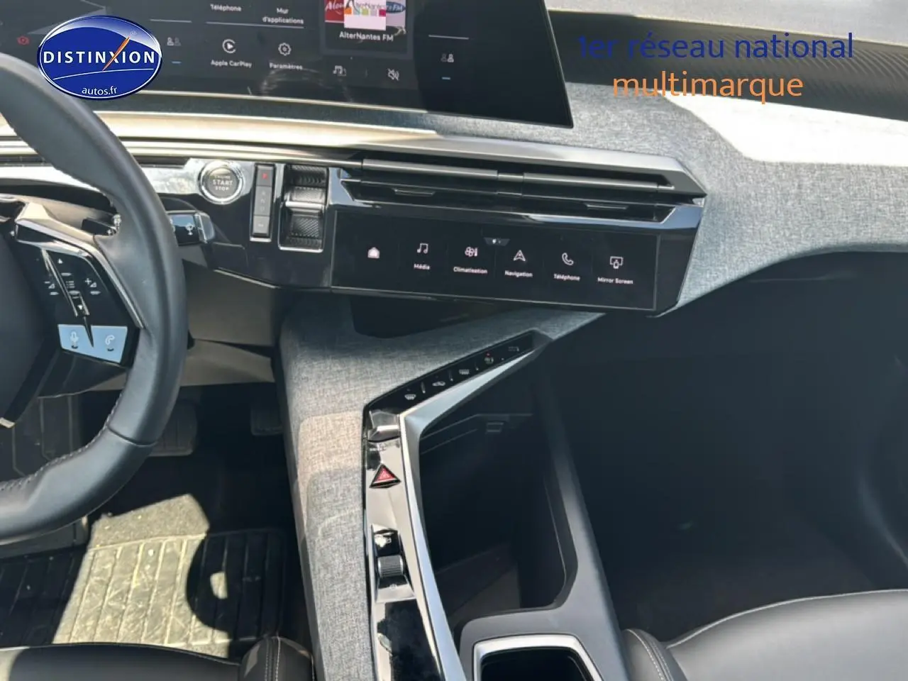Vue intérieure du tableau de bord et console centrale du Peugeot 5008 Hybrid 145 allure e-dcs6 avec sellerie noire et finitions grises.
