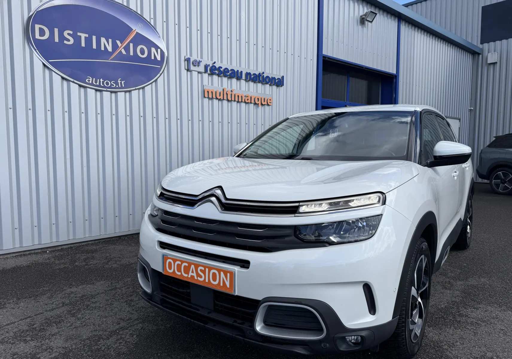 Citroën C5 Aircross blanc en 3/4 avant droit, avec calandre distinctive et plaque "OCCASION" orange visible.
