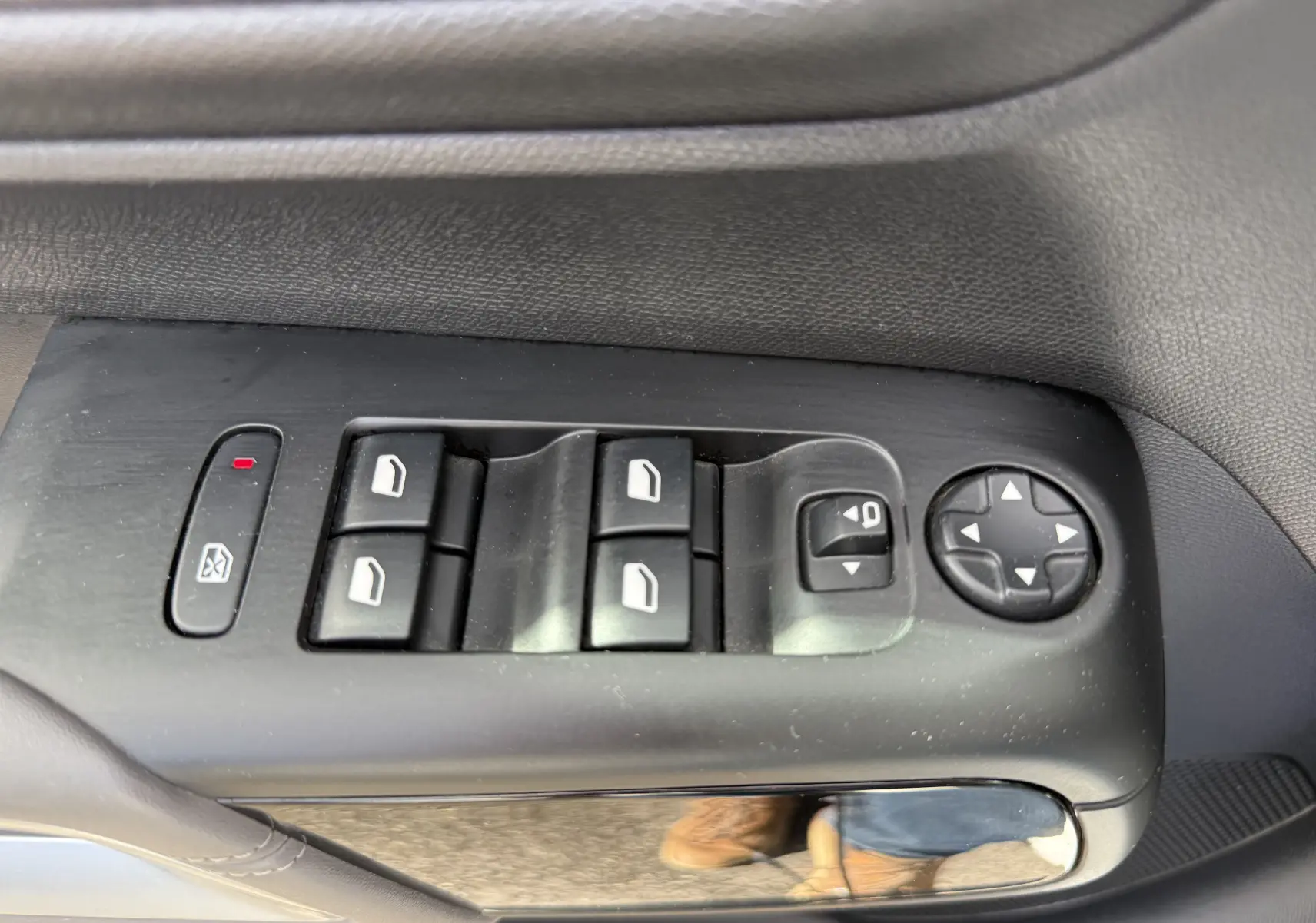 Gros plan sur les commandes des vitres électriques et des rétroviseurs côté conducteur d’un Citroën C5 Aircross blanc.