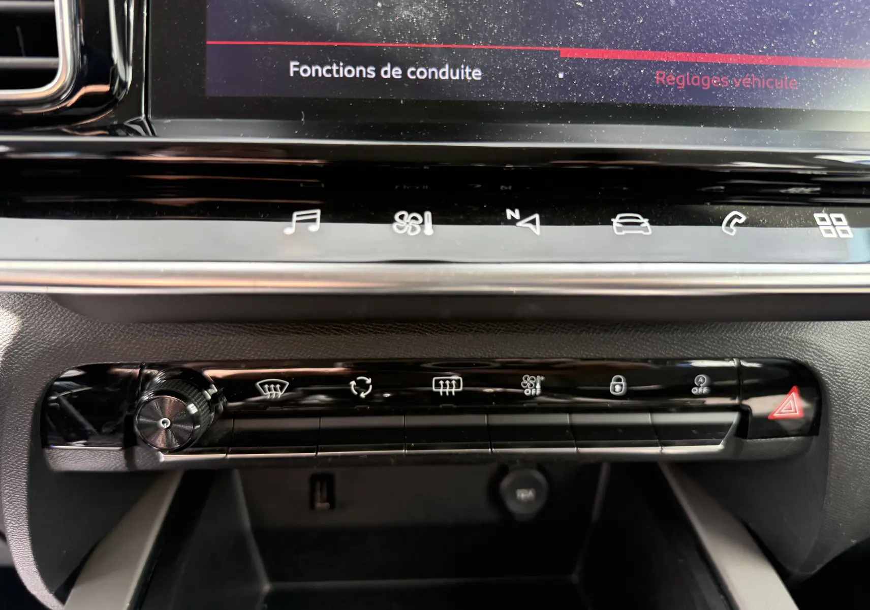 Gros plan sur la console centrale tactile du Citroën C5 Aircross 2021, boutons de commande et écran affichant fonctions de conduite.