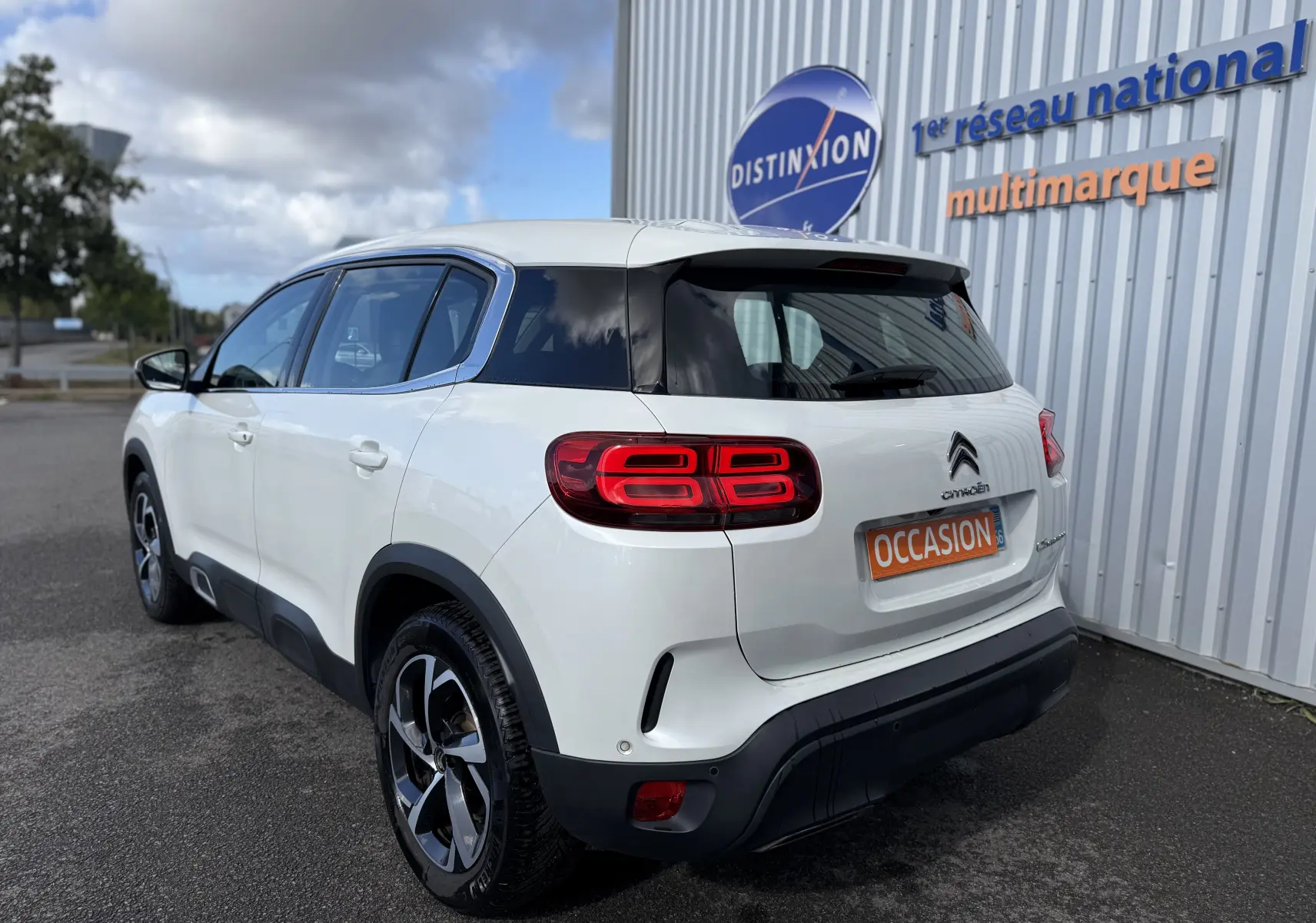 Vue 3/4 arrière droite d'un Citroën C5 Aircross blanc avec feux arrière LED et jantes bi-ton.