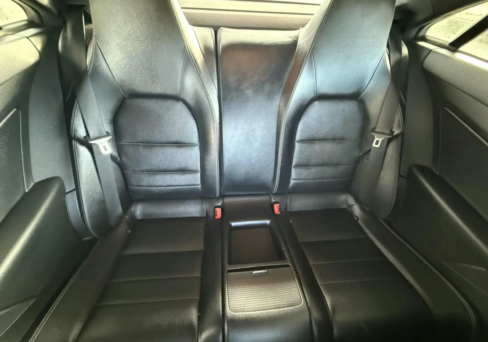 Vue intérieure arrière montrant les sièges en cuir noir du Mercedes Classe E 250 Coupé gris de 2011.