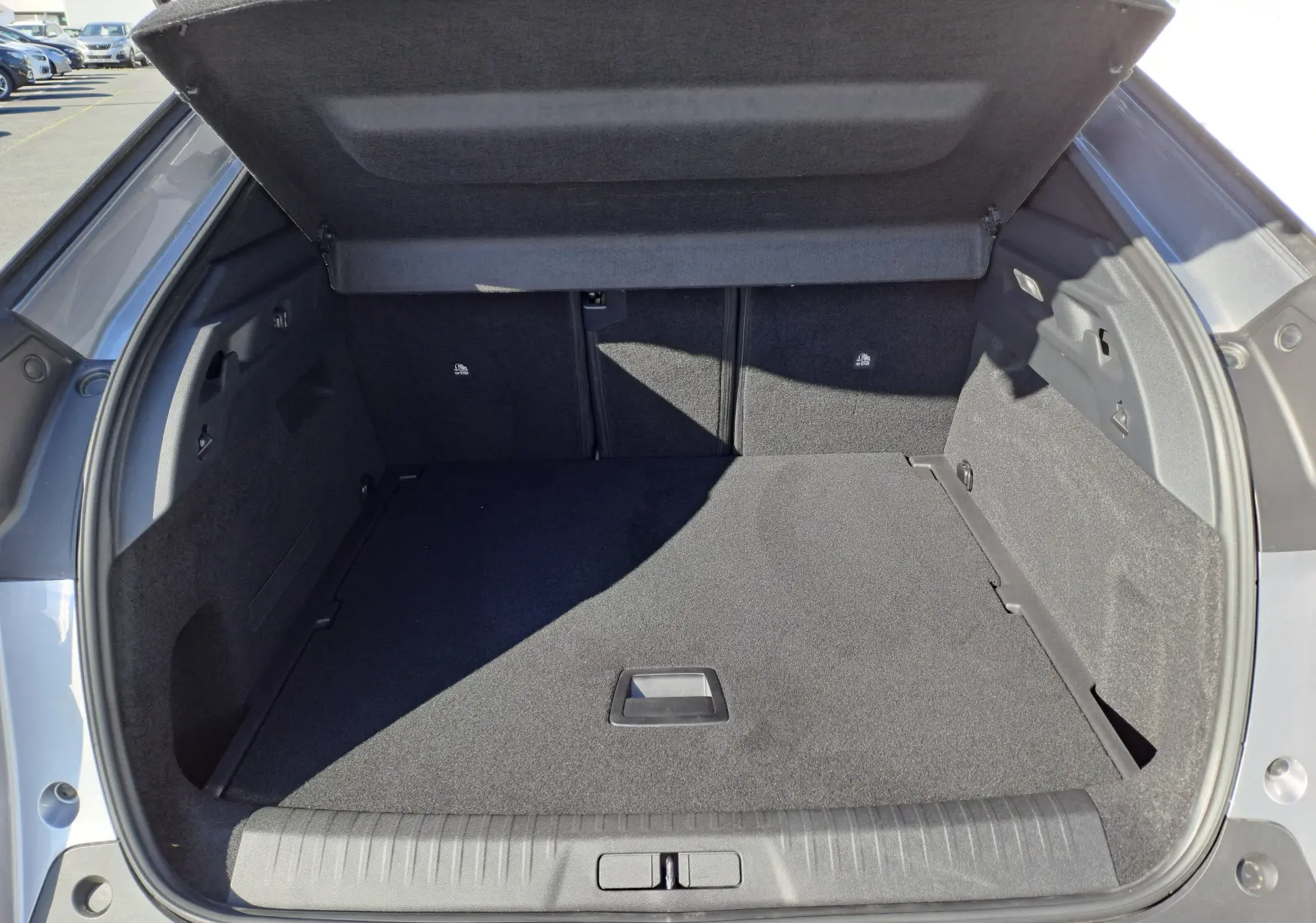 Coffre ouvert du Peugeot 3008 gris Artense, vue arrière montrant un espace de chargement propre et spacieux.