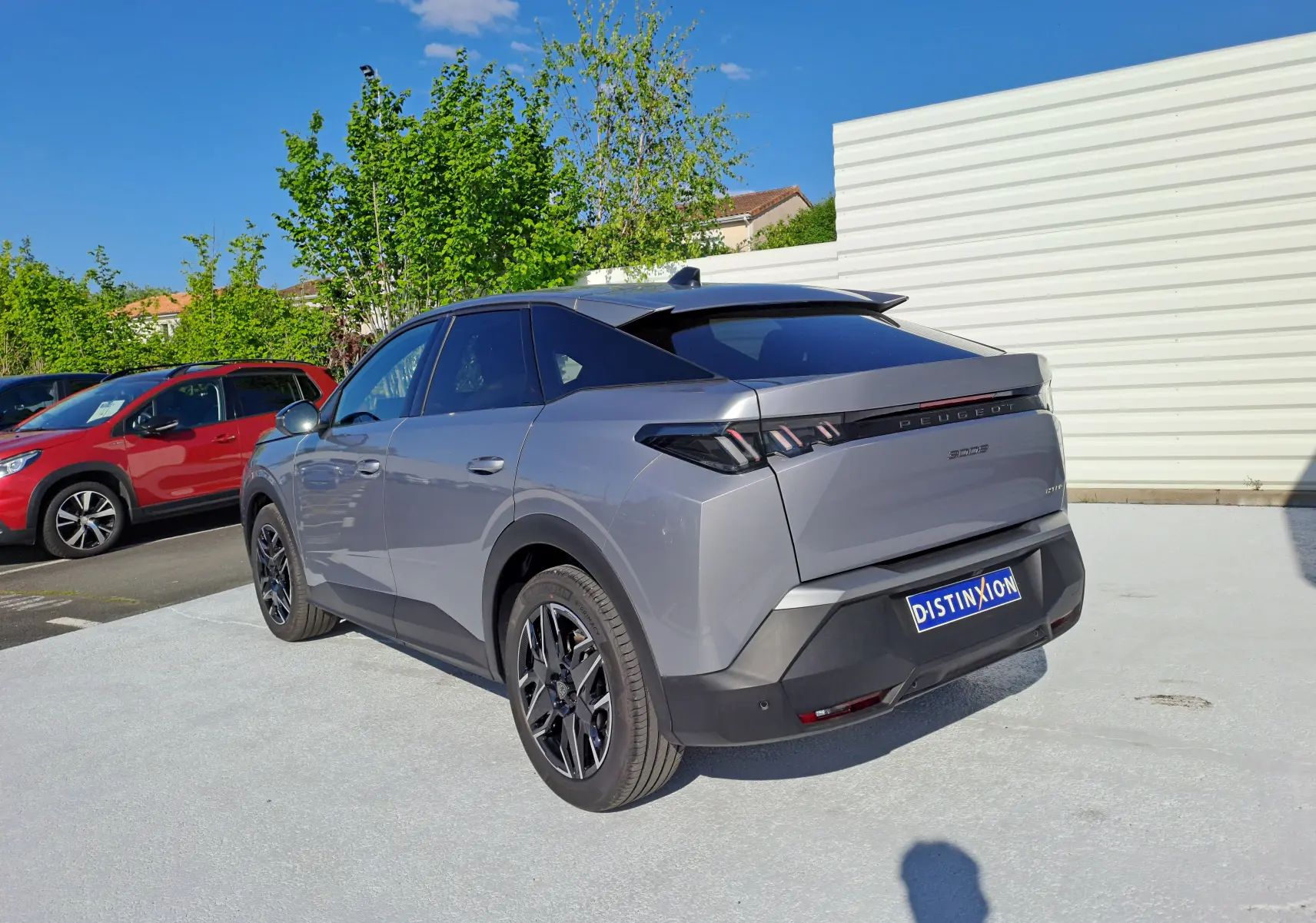 Peugeot 3008 hybride gris Artense vue 3/4 arrière droit, avec feux arrière LED et jantes noires.