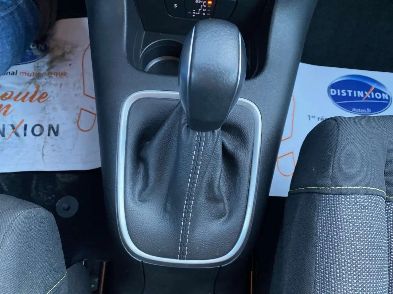 Le levier de vitesses automatique noir avec surpiqûres blanches sur la console centrale d'une Citroën C3 Shine 2023.