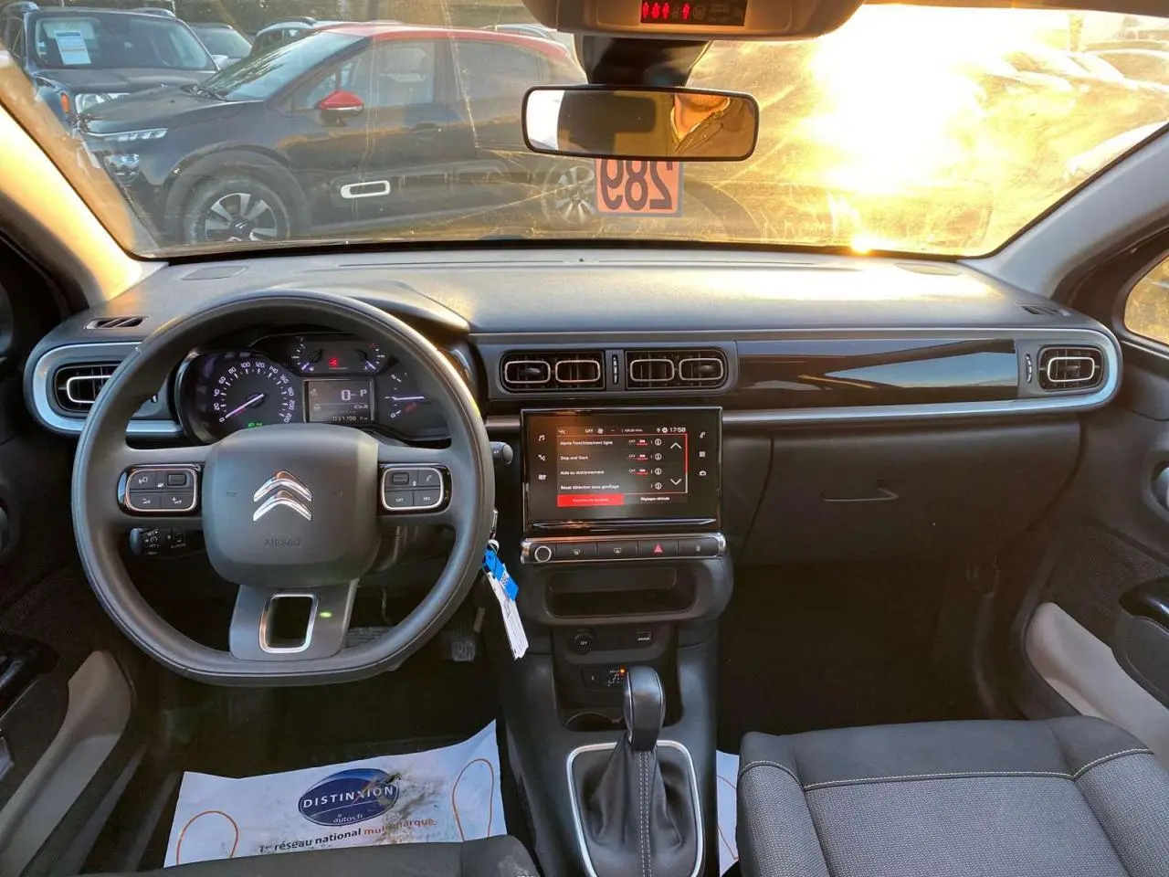 Vue intérieure avant du tableau de bord noir de la Citroën C3 Shine 2023 avec écran tactile et volant multifonction.