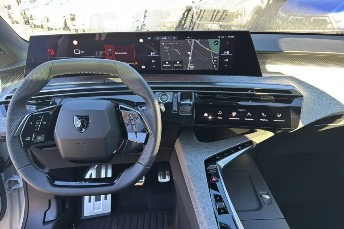 Intérieur du Peugeot 3008 Hybrid 2024, vue du poste de conduite avec tableau de bord numérique et volant multifonction.