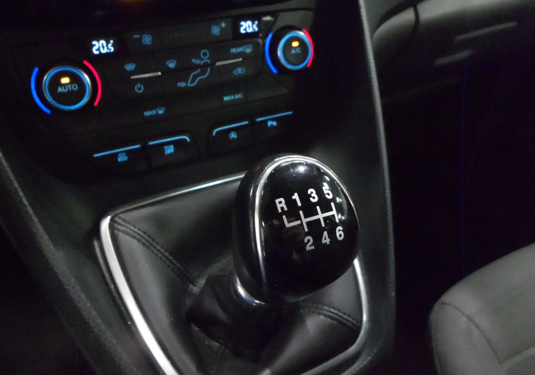 Gros plan sur le levier de vitesses manuel noir du Ford Grand Tourneo Connect 2020 avec commandes climatisation en arrière-plan.