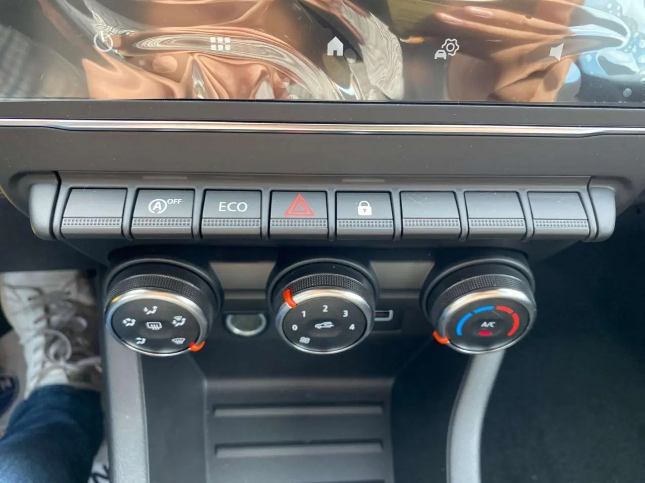 Gros plan sur la console centrale de la Renault Clio 2025 avec commandes de climatisation et boutons fonctionnels.