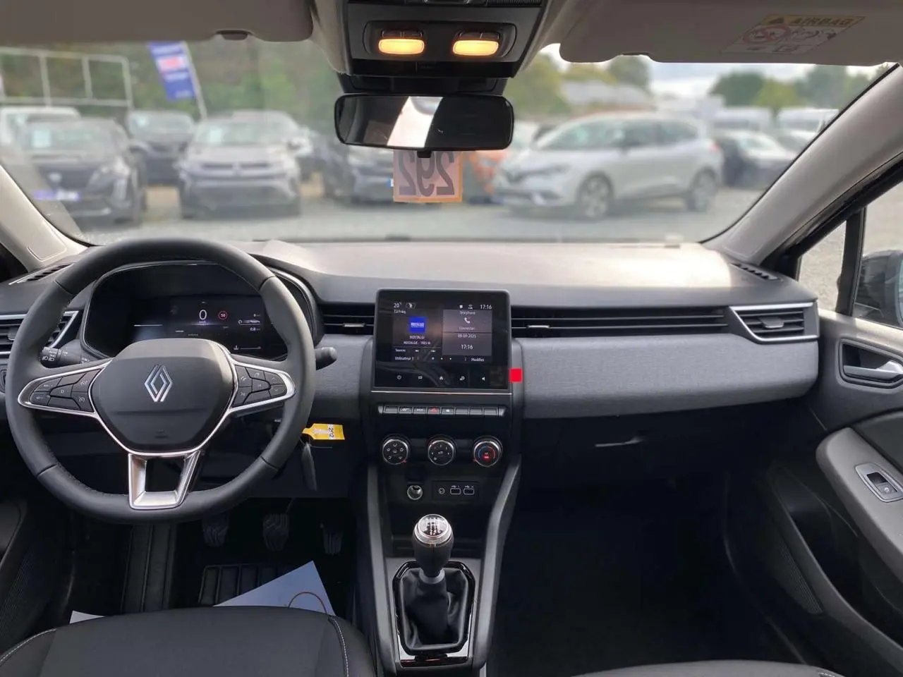 Intérieur de la Renault Clio 2025 noir étoilé, vue de face sur le tableau de bord avec écran tactile et boîte manuelle.