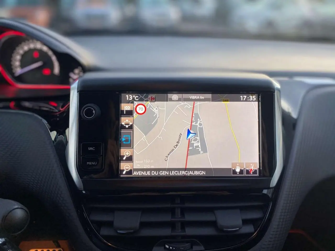 Vue rapprochée de l'écran tactile central avec navigation GPS dans l'habitacle d'une Peugeot 2008 blanche de 2016.