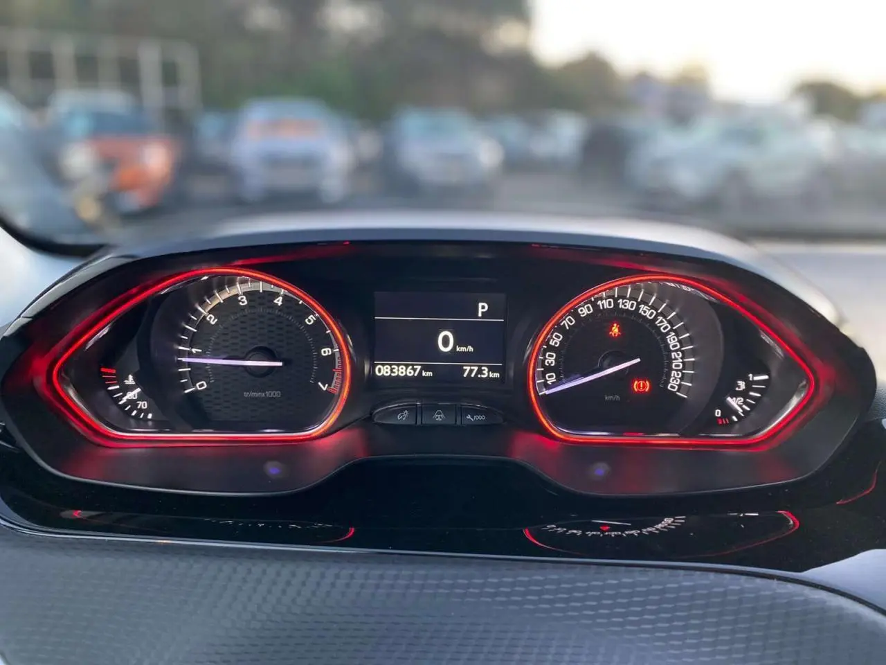 Tableau de bord du Peugeot 2008 GT Line 2016, affichage numérique avec compte-tours et vitesse entourés de lumière rouge.