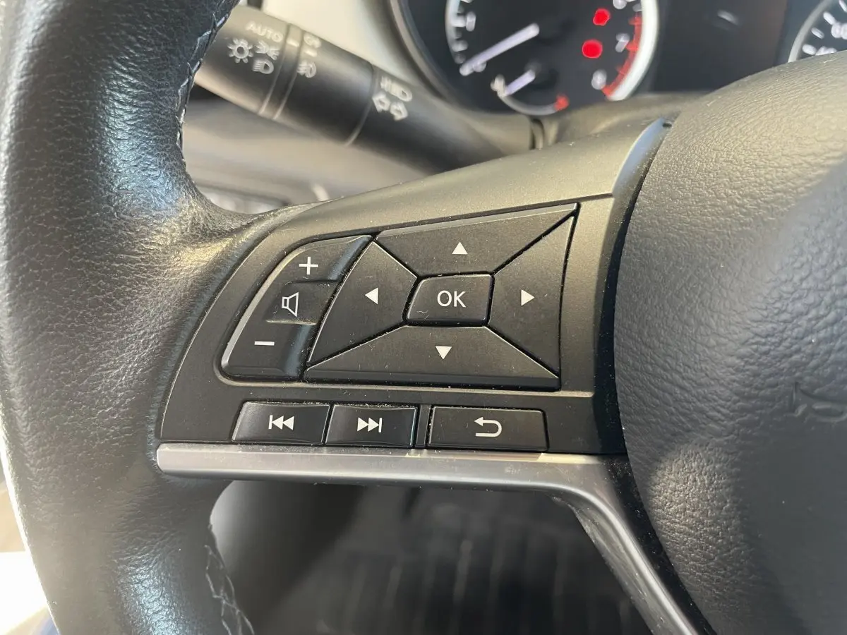 Gros plan sur les commandes multifonctions du volant en cuir noir d'une Nissan Micra IG-T 100 N-Connecta 2020.