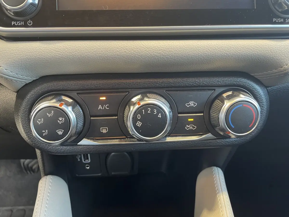 Commandes de climatisation manuelle en gros plan dans l'habitacle beige d'une Nissan Micra IG-T 100 N-Connecta 2020.