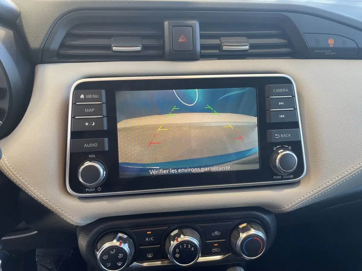 Vue rapprochée de l'écran tactile du tableau de bord beige de la Nissan Micra bleu, affichant la caméra de recul.