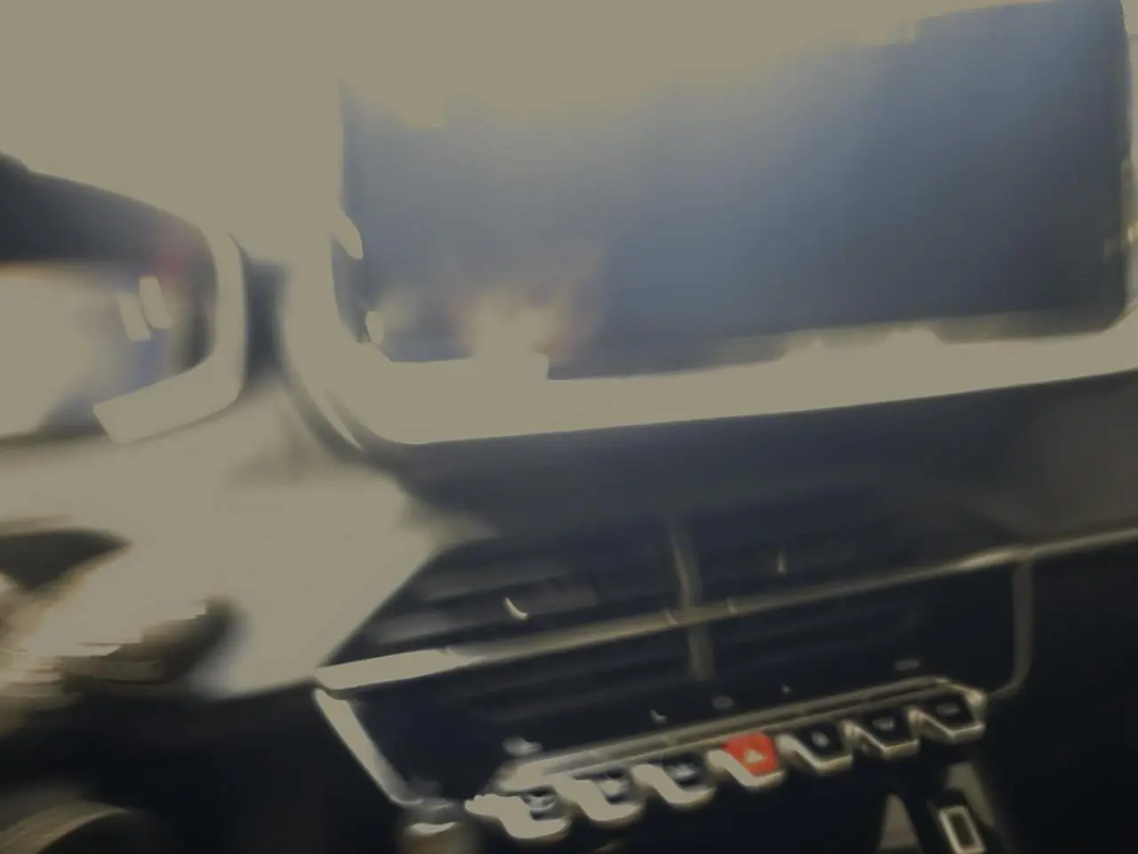 Tableau de bord noir de Peugeot 208 1.2i Hybrid 2025 avec écran tactile et commandes piano.