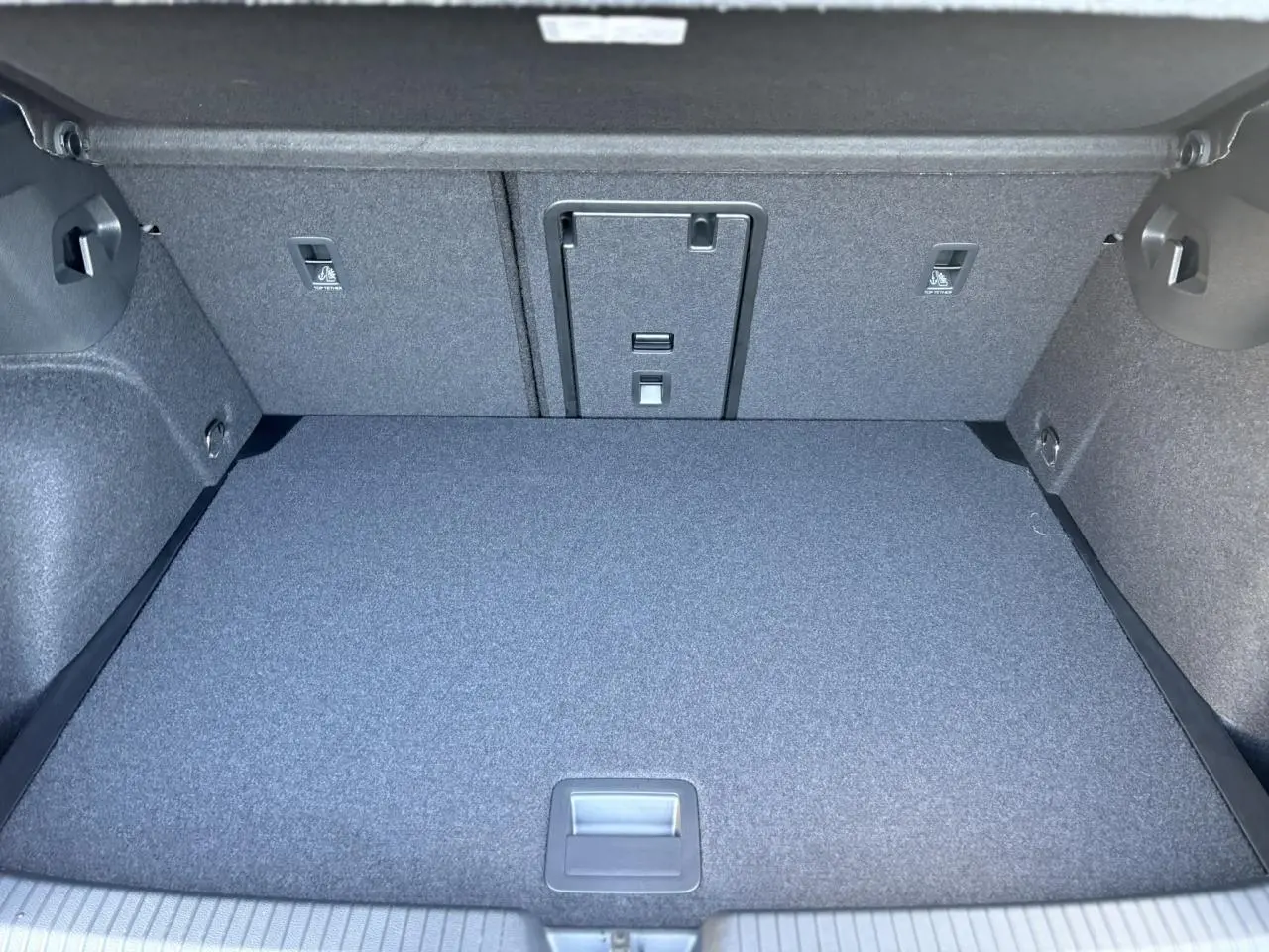 Coffre spacieux et propre de Volkswagen Golf VIII gris dauphin, vue intérieure arrière avec banquette rabattable.