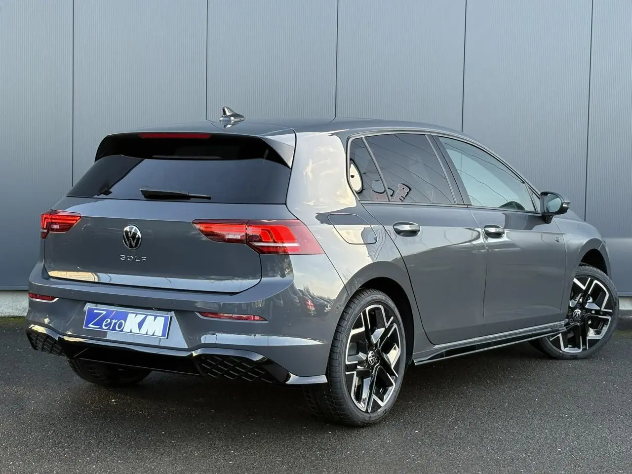 Volkswagen Golf VIII gris dauphin vue 3/4 arrière droit avec jantes alliage 18 pouces et toit ouvrant panoramique.