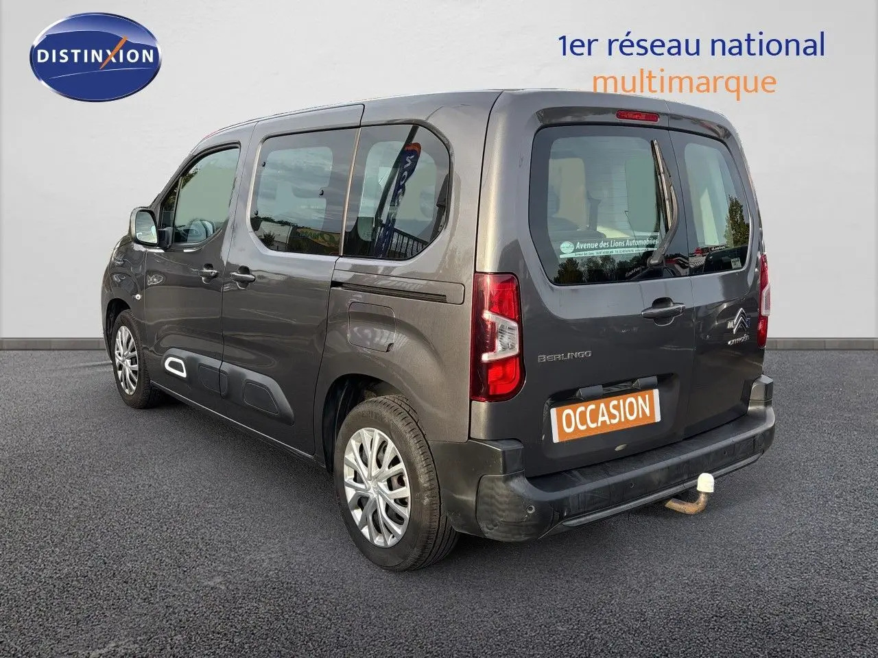 Vue 3/4 arrière droite d'un Citroën Berlingo Multispace gris platinium avec attelage, sur fond neutre.