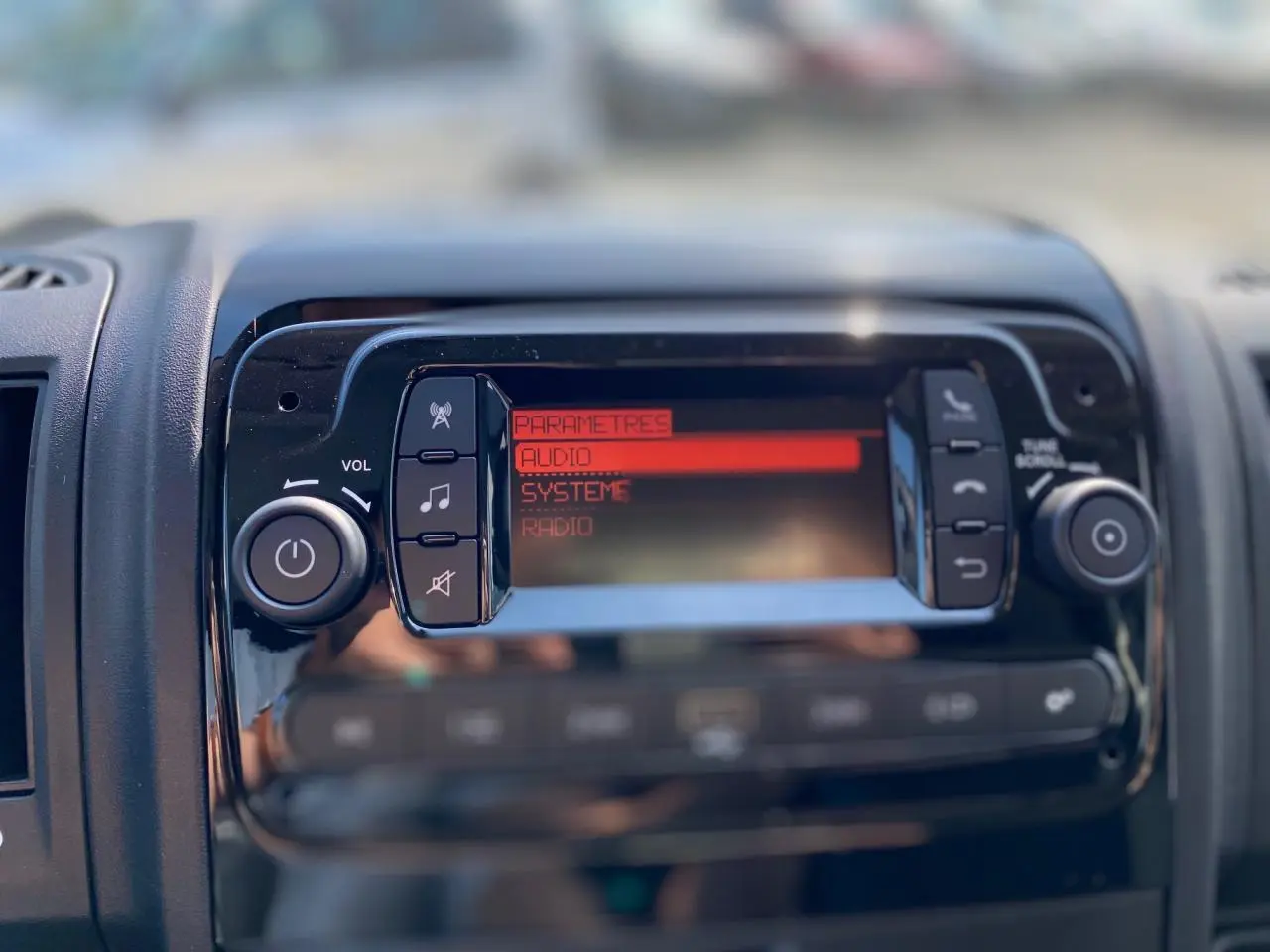 Détail de la console centrale du Citroën Jumper 2023 avec écran audio affichant les paramètres en rouge.