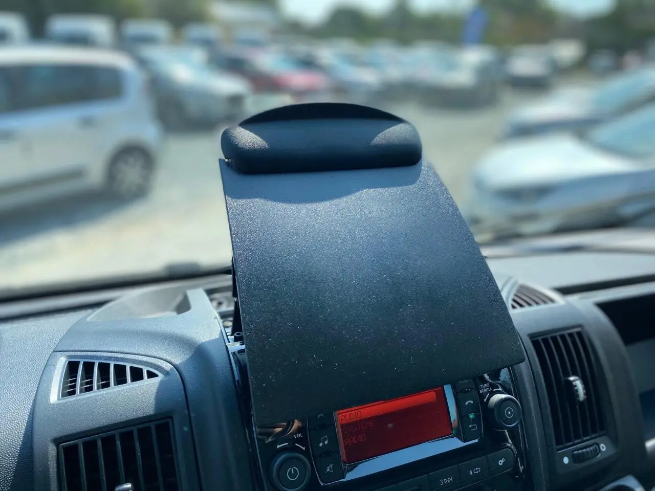 Tablette repliable au-dessus de la console centrale du tableau de bord du Citroën Jumper blanc 2023, vue intérieure frontale.