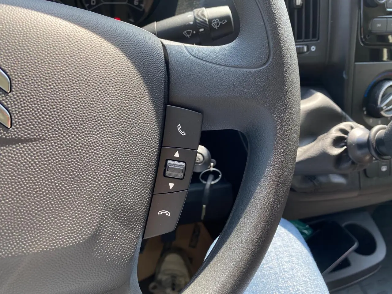 Gros plan sur le volant noir du Citroën Jumper 2023 avec commandes d'appel intégrées et levier de vitesses visible.