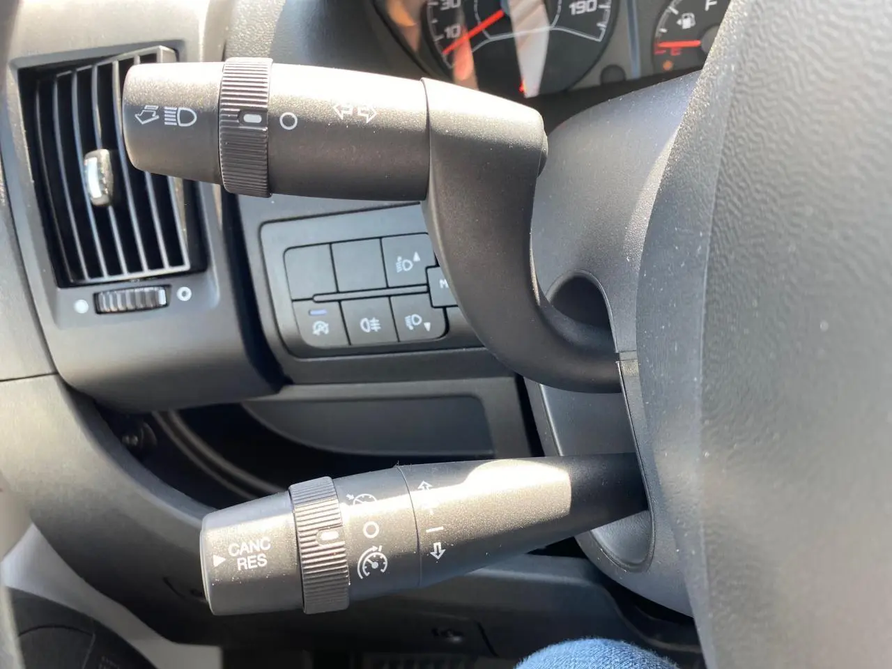 Gros plan sur les commandes au volant du Citroën Jumper 2023, avec régulateur de vitesse et leviers noirs.