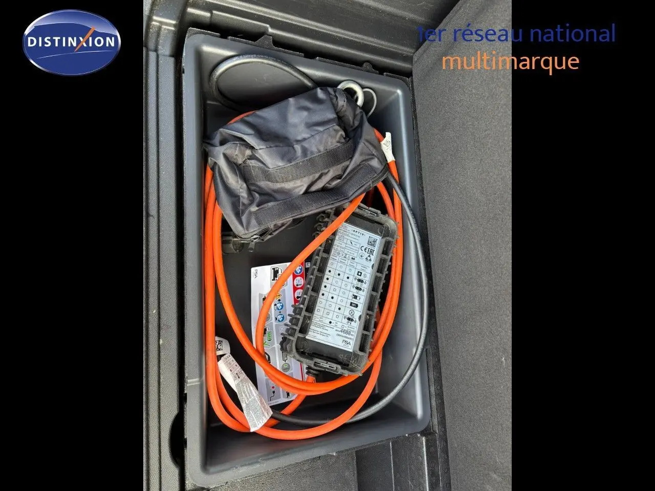 Vue plongeante sur le coffre d'un Peugeot 3008 gris platinium, montrant le câble de recharge hybride rangé.