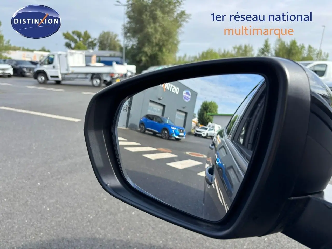 Rétroviseur côté droit montrant la carrosserie gris platinium du Peugeot 3008 hybride rechargeable 2022 en extérieur.