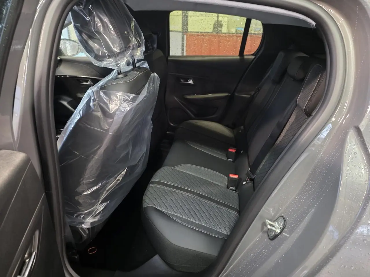 Vue intérieure côté droit de la banquette arrière tissu noir et gris d'une Peugeot 208 Gris Selenium 2025.