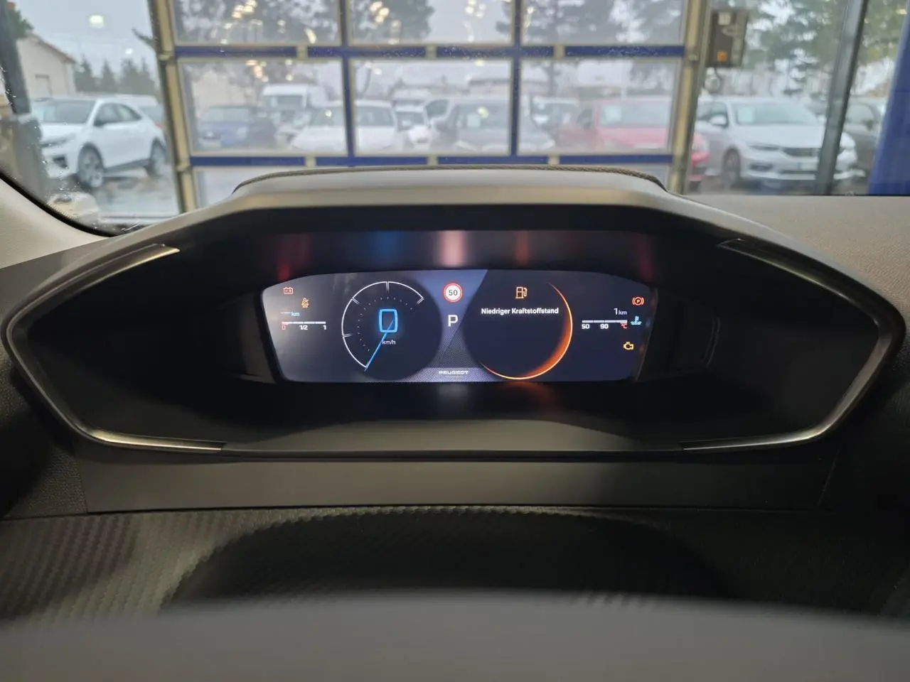 Tableau de bord numérique de Peugeot 208 hybride, affichage digital clair avec indicateurs de vitesse et alertes.