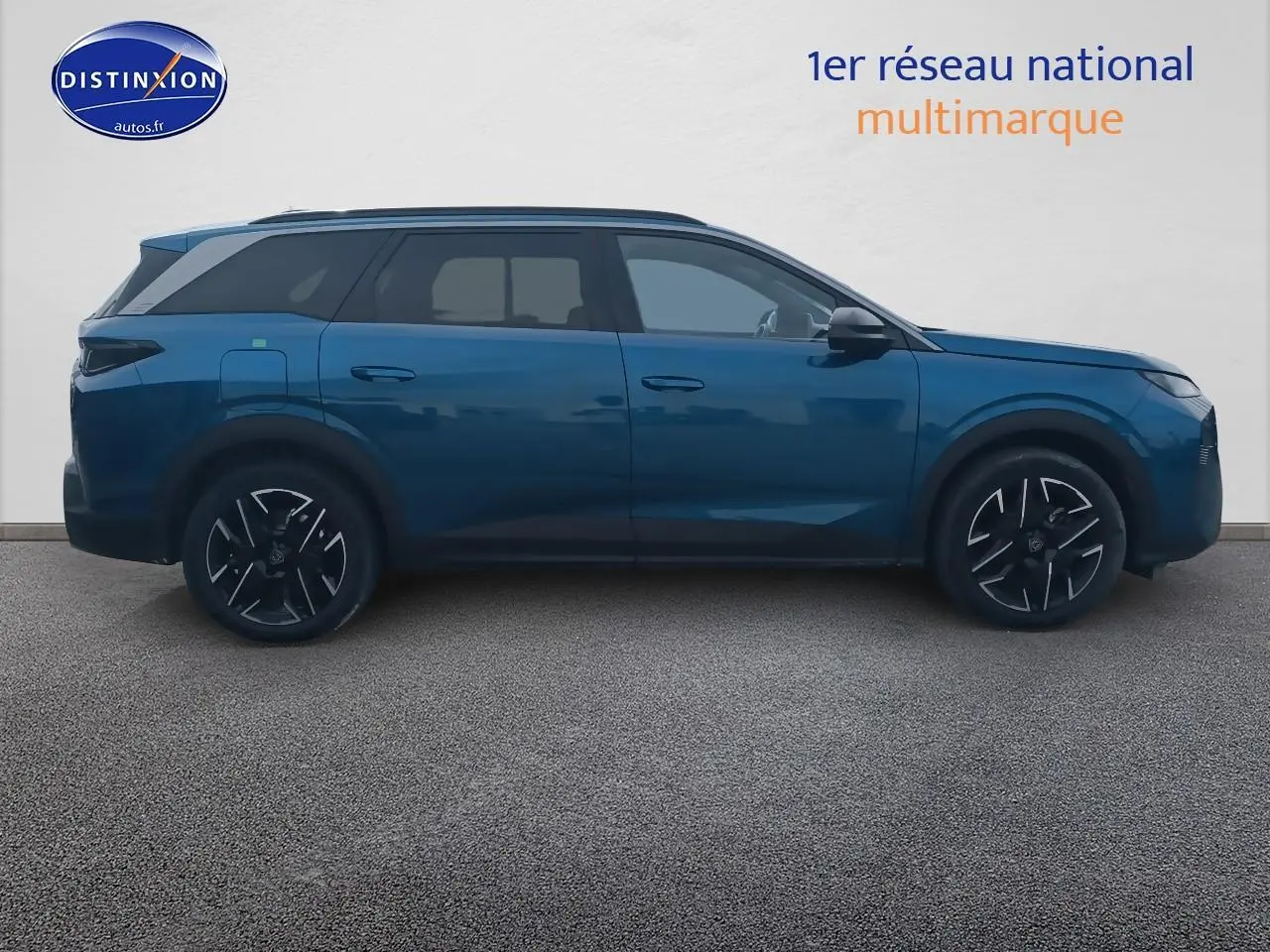 Profil latéral droit d’un Peugeot 5008 Hybrid 145 allure e-dcs6 bleu avec jantes alu et vitres surteintées.