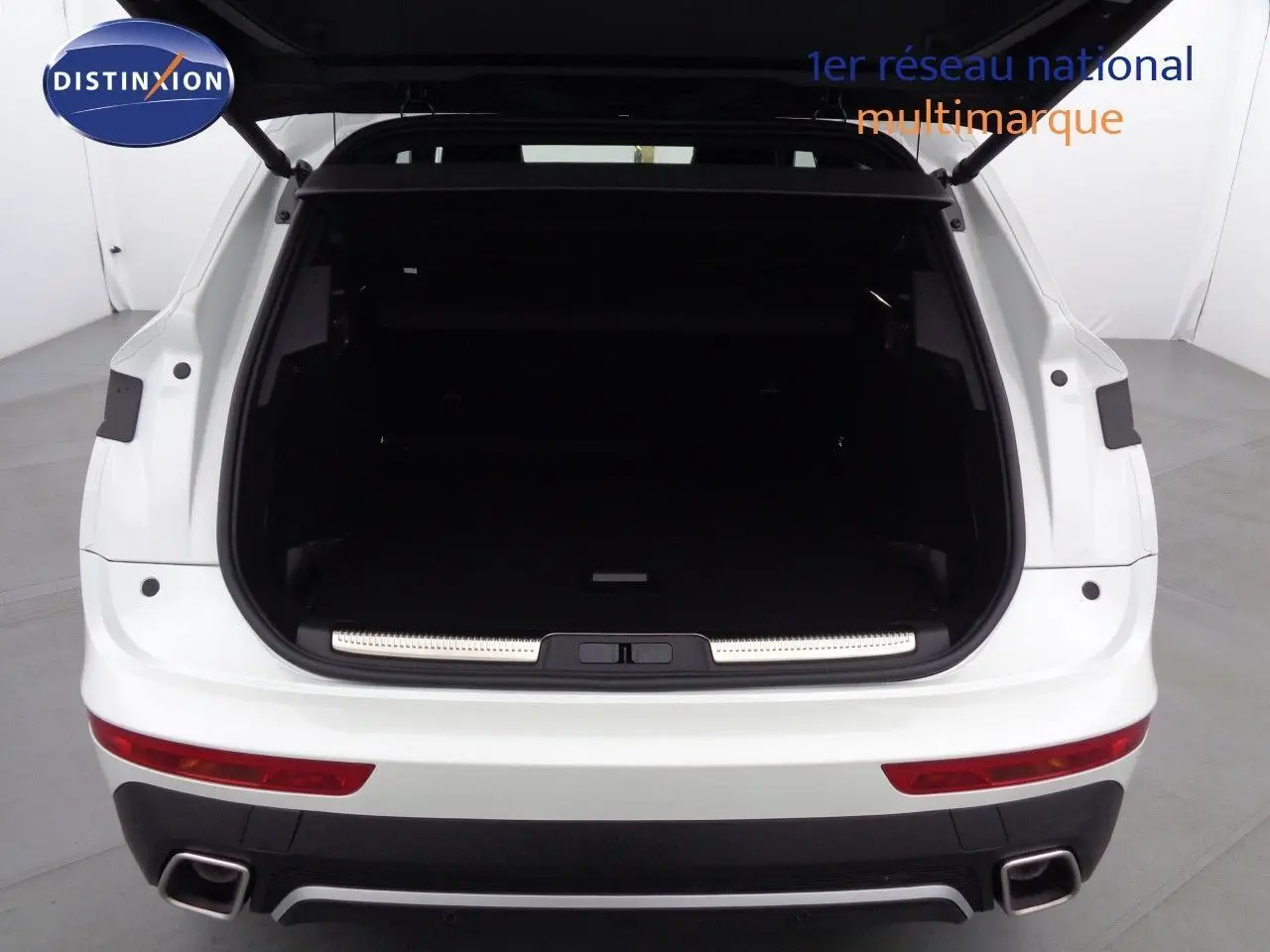 Vue arrière du coffre ouvert d'un DS7 Crossback E-TENSE blanc nacré, soulignant l'espace de chargement vide.