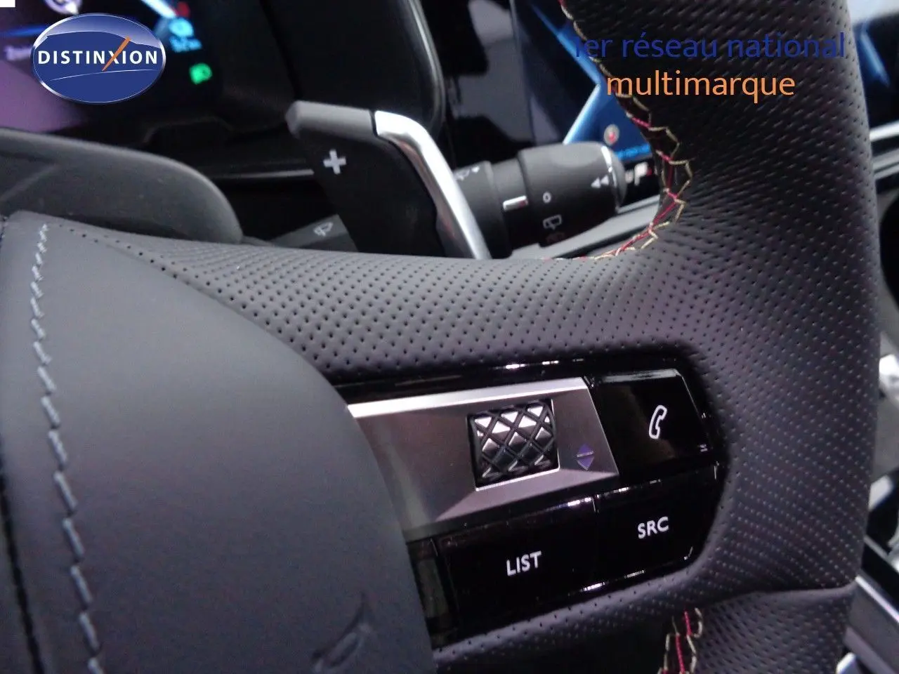 Gros plan sur le volant en cuir noir perforé du DS7 Crossback E-TENSE 300CH, avec commandes intégrées visibles.