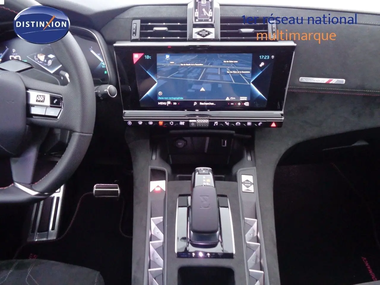 Vue intérieure centrée sur la console et le tableau de bord du DS7 Crossback blanc nacré avec écran tactile et volant cuir noir.