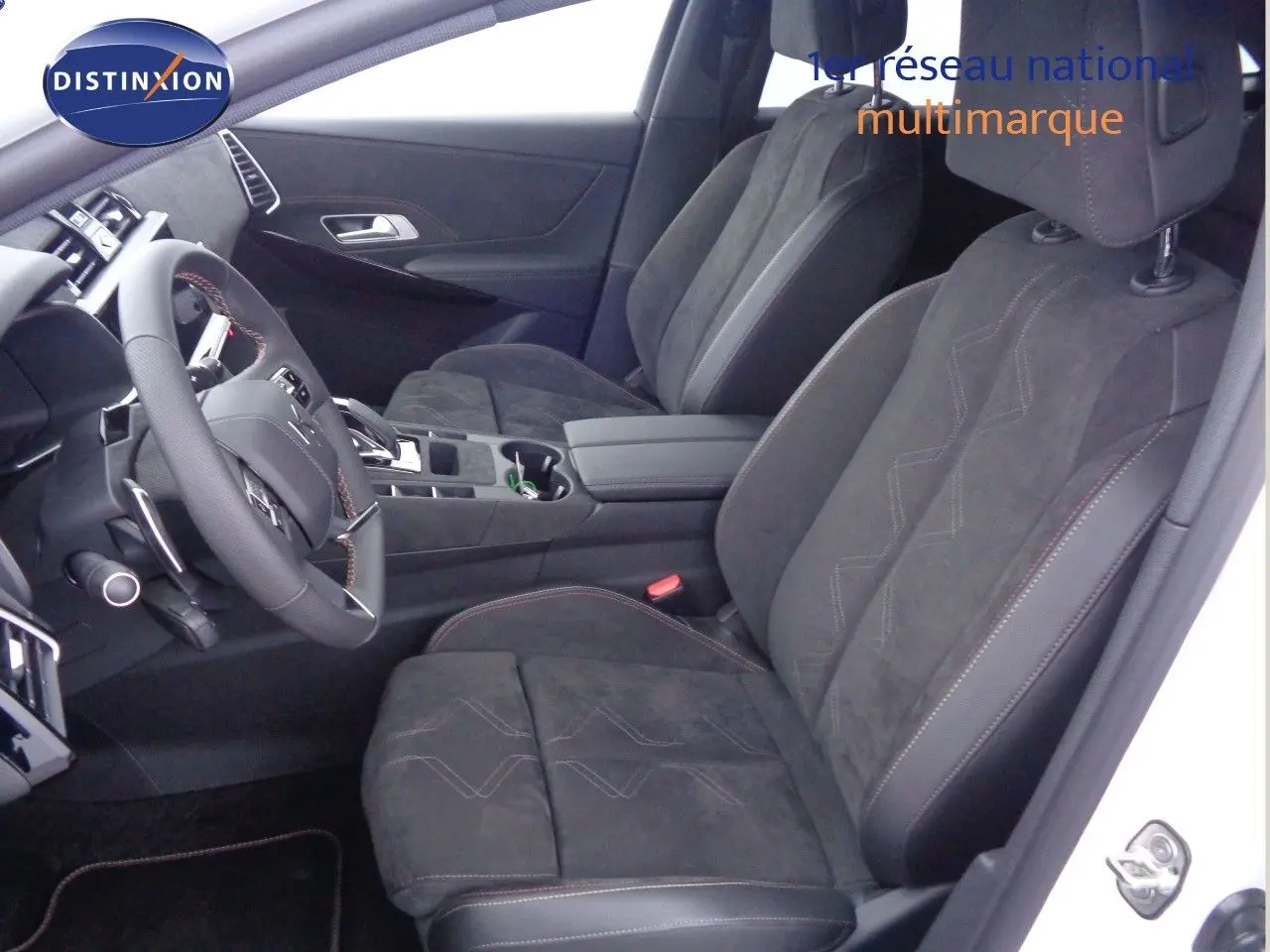 Vue intérieure côté conducteur du DS7 Crossback E-TENSE 300CH en blanc nacré, sièges en cuir noir avec surpiqûres rouges.