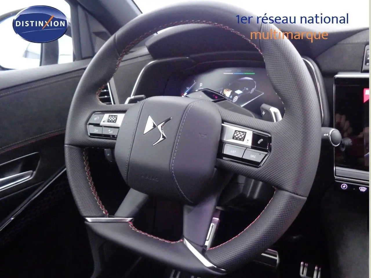 Volant en cuir perforé avec surpiqûres rouges du DS7 Crossback E-TENSE 300CH 4X4, vue rapprochée de l'intérieur conducteur.