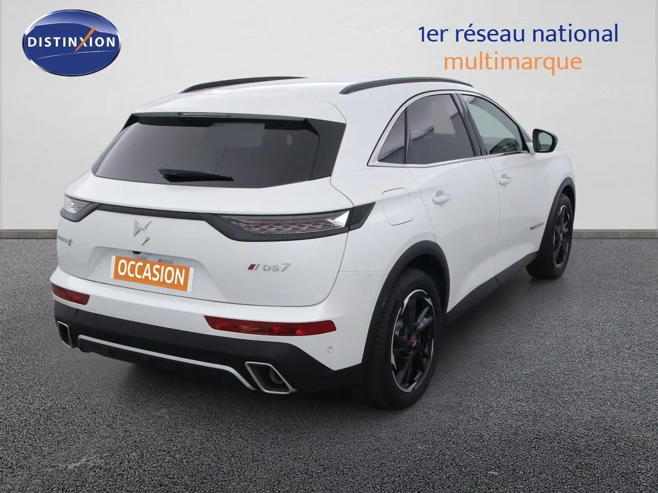 Vue 3/4 arrière droite d'un DS7 Crossback blanc nacré avec jantes noires et feux arrière effilés.