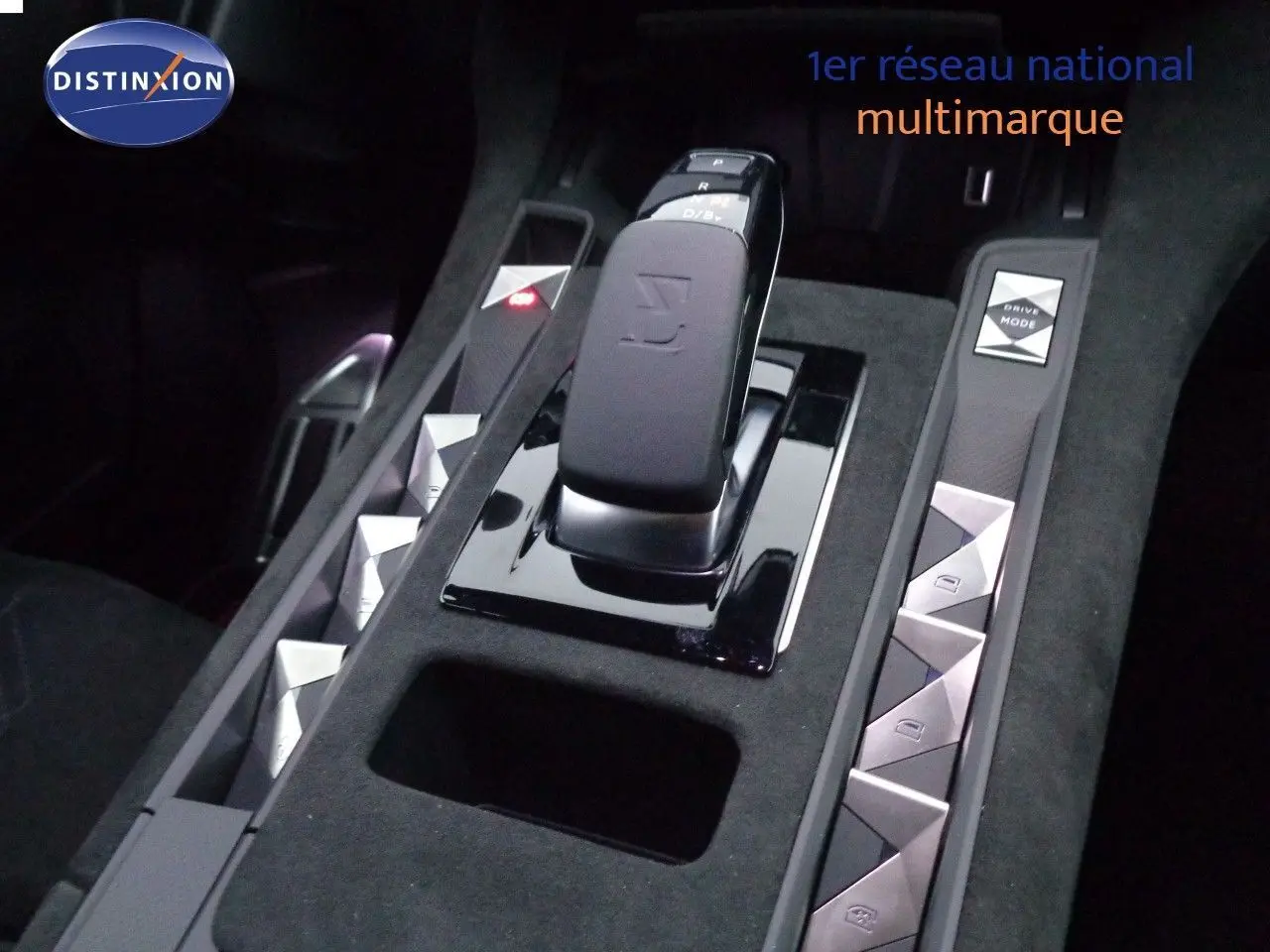 Gros plan sur la console centrale noire du DS7 Crossback E-TENSE 300CH avec levier de vitesses et commandes argentées.