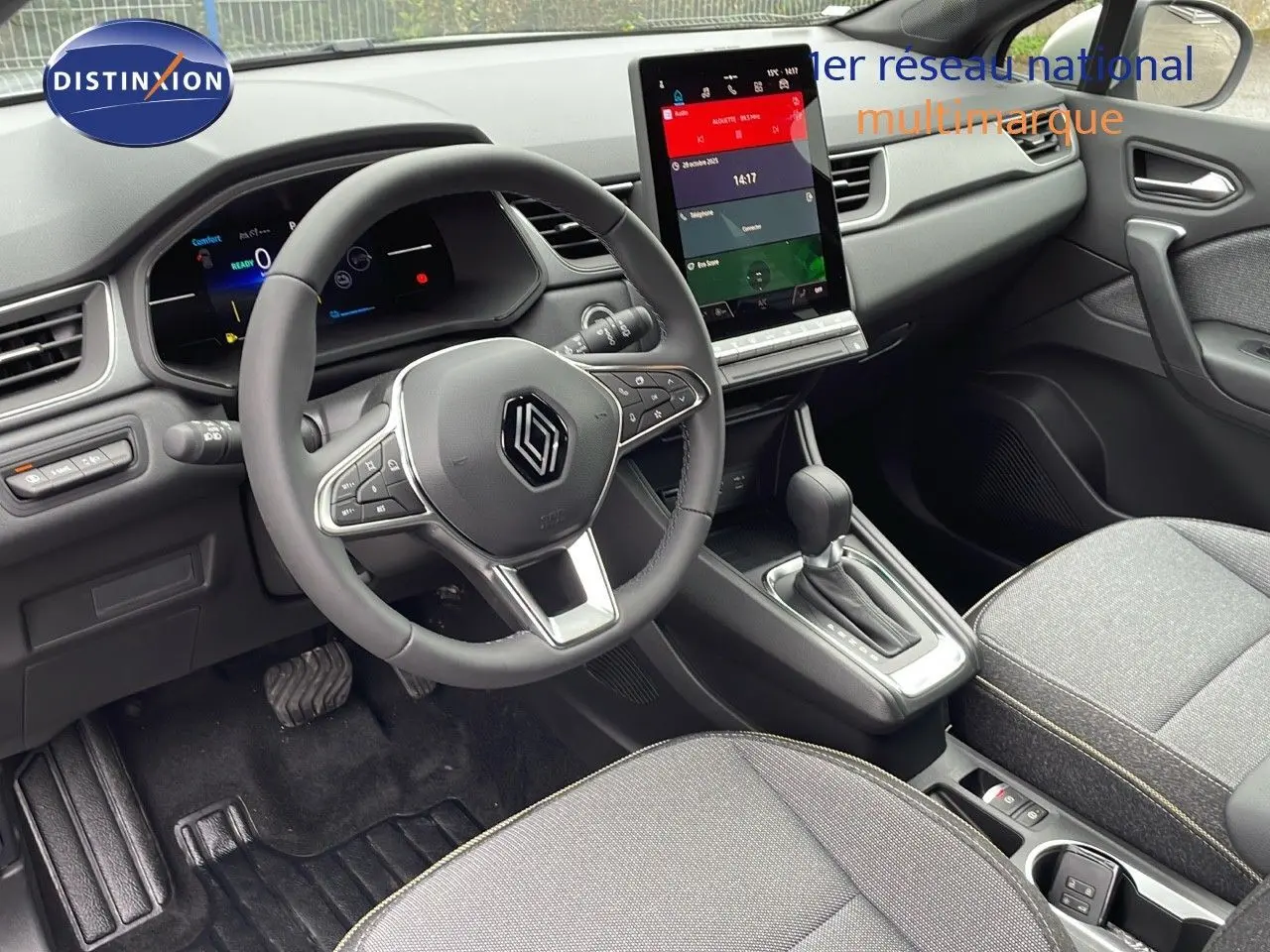 Vue intérieure côté conducteur du Renault Captur 2025, tableau de bord moderne avec écran tactile vertical et volant multifonction.