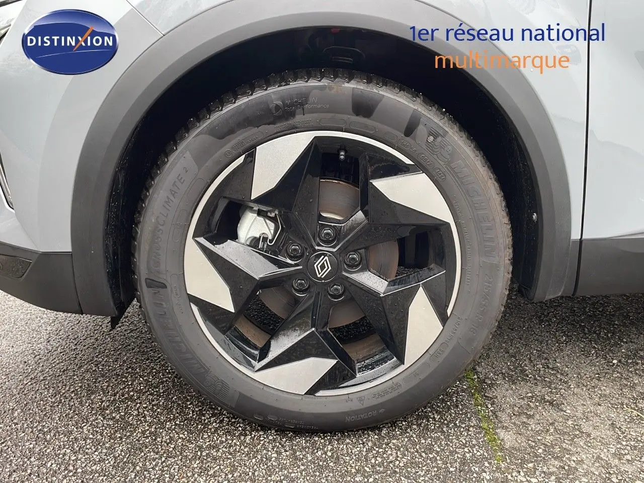 Gros plan sur la roue avant gauche du Renault Captur gris Rafale Métal avec jante noire et argentée au design géométrique.