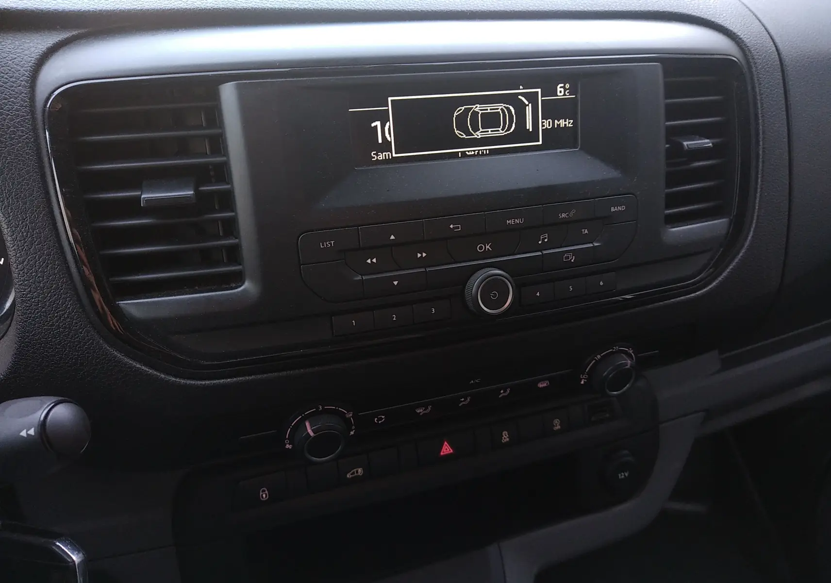 Tableau de bord du Citroën Jumpy Fourgon 2021, vue centrée sur la console radio et climatisation, finition noire.