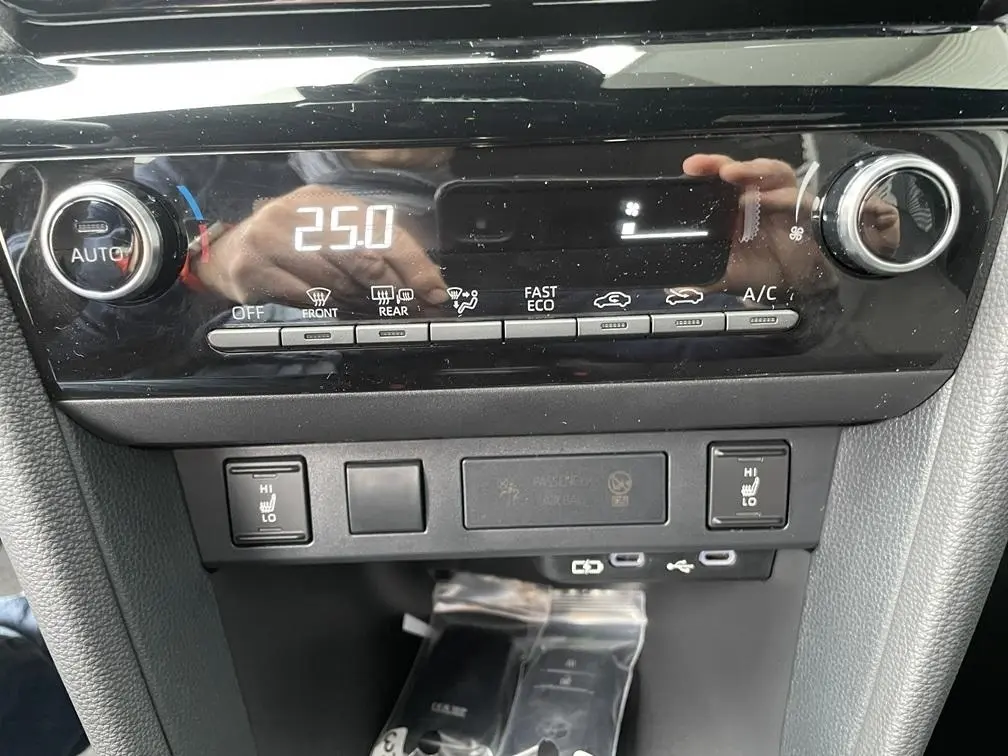 Tableau de bord de Toyota Yaris Cross 2026, vue rapprochée sur commandes climatisation et sièges chauffants.