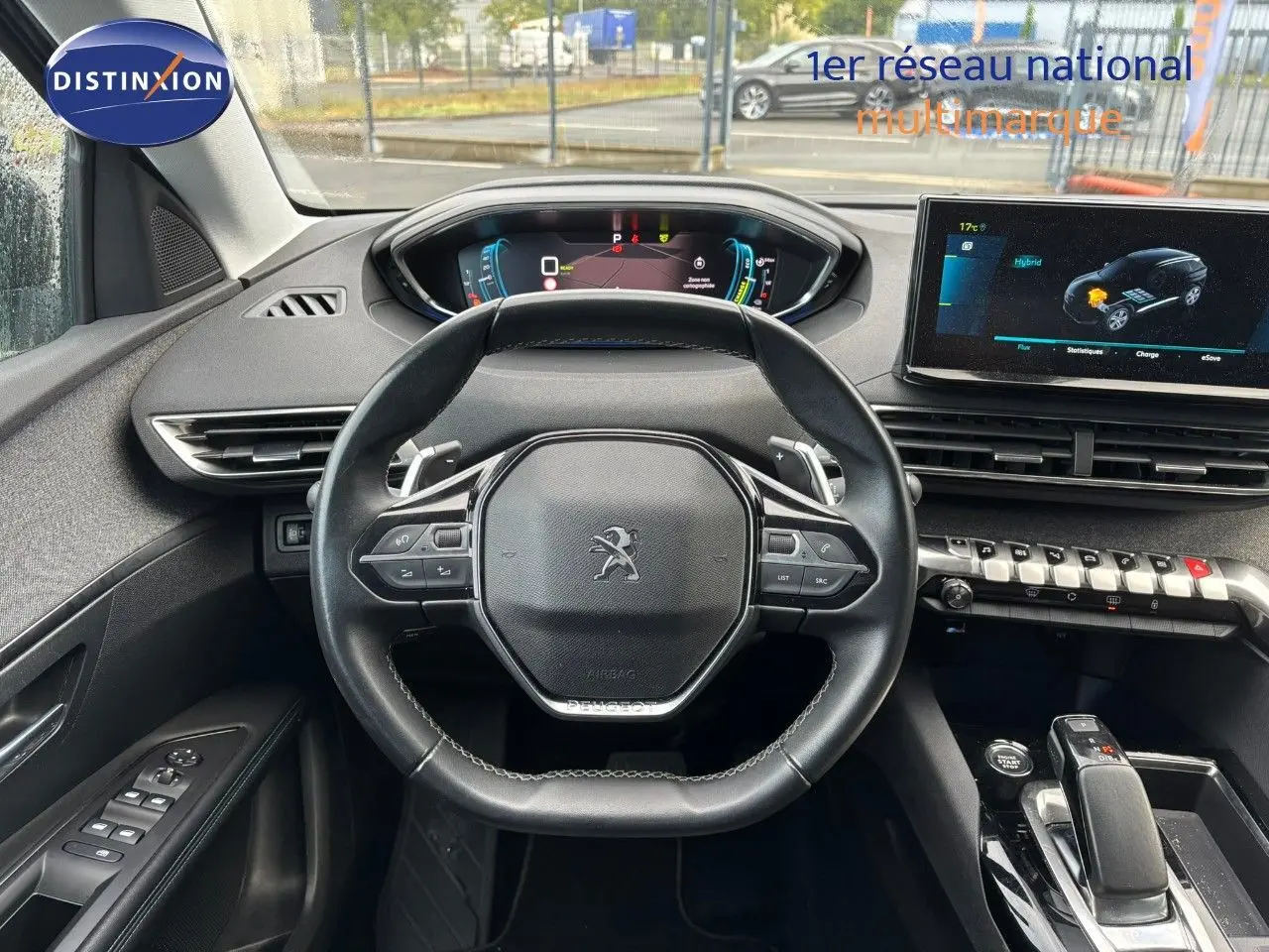 Vue intérieure centrée sur le volant Peugeot 3008 hybride 2022 avec tableau de bord numérique et écran tactile.