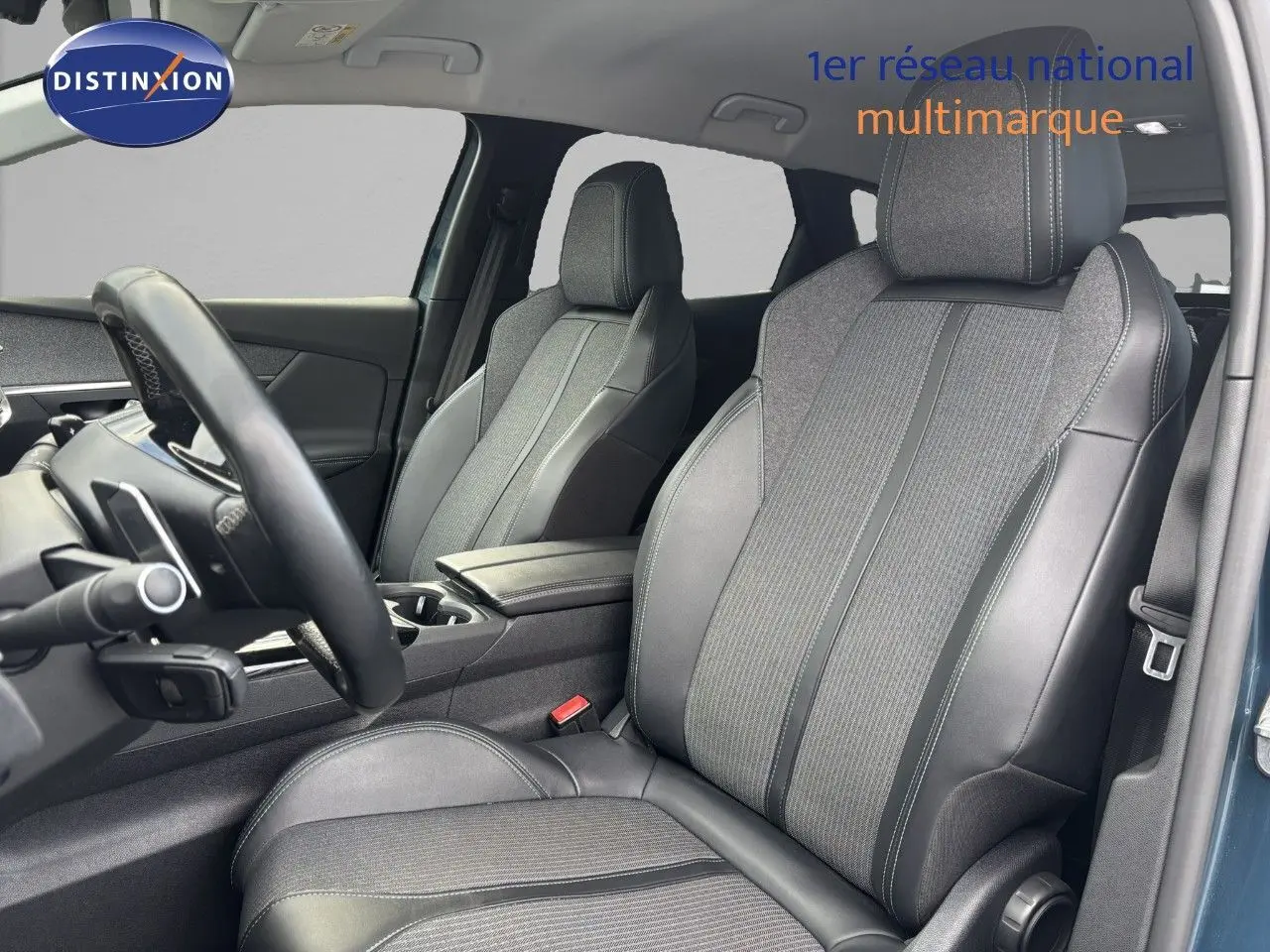 Intérieur du Peugeot 3008 hybride 2022, vue côté conducteur, sièges en cuir et tissu gris, ambiance moderne et soignée.