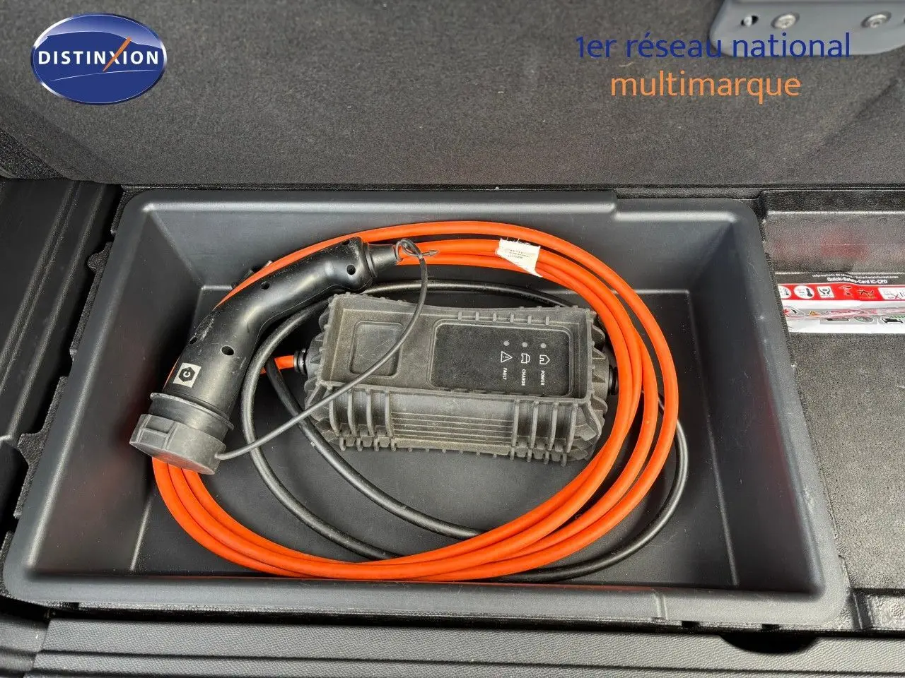 Câble de recharge orange enroulé dans le coffre du Peugeot 3008 hybride rechargeable bleu Célèbes.