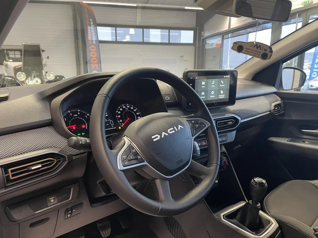 Intérieur de la Dacia Sandero Stepway 2025 vue côté conducteur, volant noir avec logo et écran tactile central.