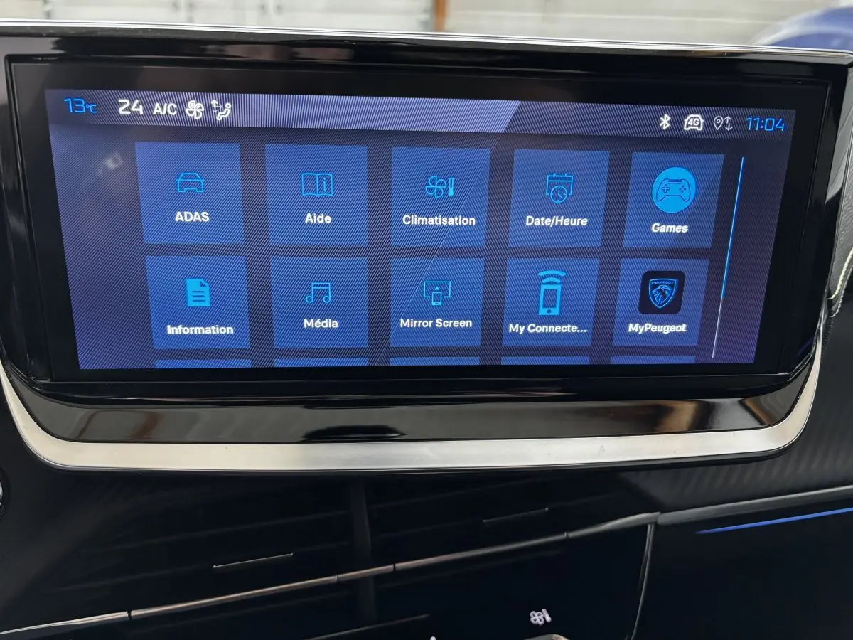 Écran tactile central affichant le menu multimédia et climatisation du Peugeot 208 Hybrid 110 GT, intérieur noir.