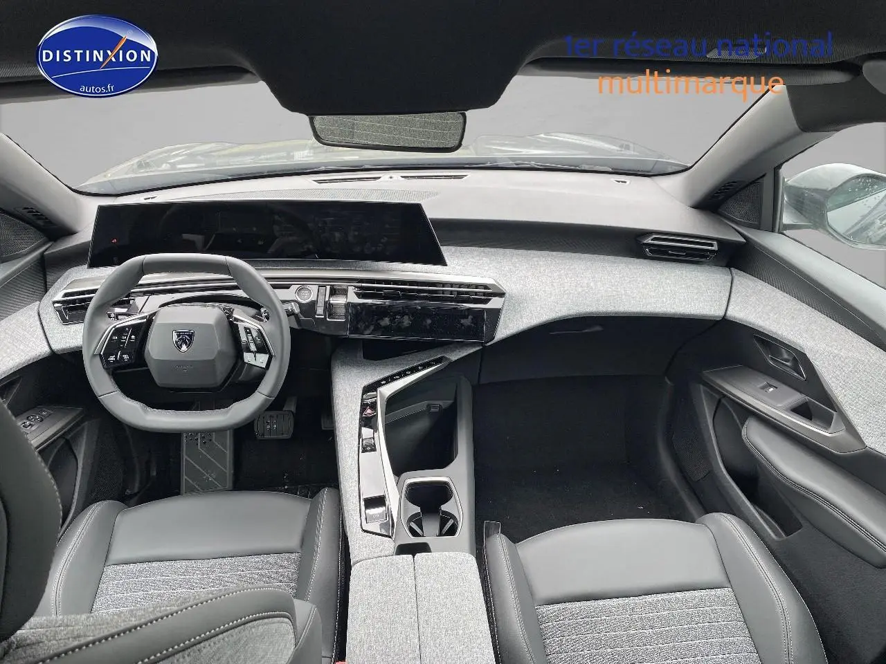 Vue intérieure avant du Peugeot 5008 Hybrid 145 allure e-dcs6 avec tableau de bord gris clair et sièges bi-matière gris et noir.
