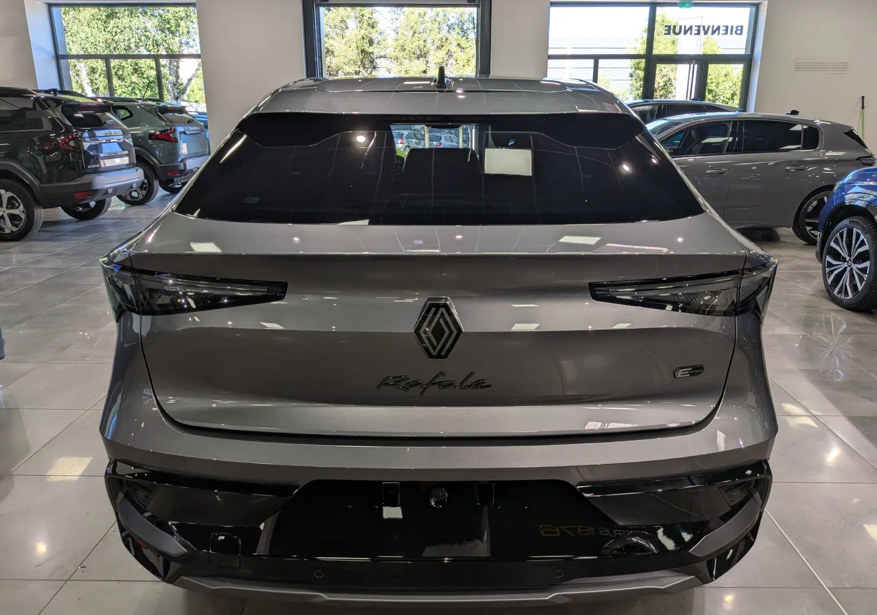 Vue arrière du Renault Rafale gris schiste en version hyper hybrid E-Tech, avec feux arrière effilés et logo central visible.